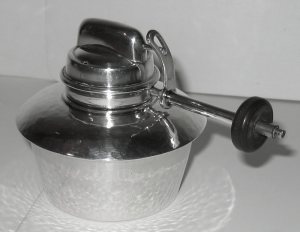 burner on a silver tea kettle manufactured by Liberty & Co