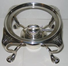 burner on a silver tea kettle manufactured by Liberty & Co