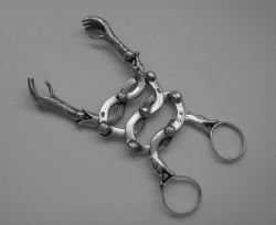 Sugar tongs featuring an intricate snake pattern ending in two claws