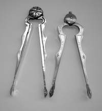 two compass-shaped sugar tongs