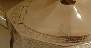Small Calley family crest integrated with the double-dot pattern surrounding the lid