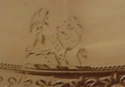 Small Calley family crest integrated with the double-dot pattern surrounding the lid