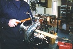 Sometimes a highly polished planishing hammer must be used to force down pinpoint dents