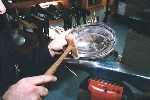 A wooden hammer is used to remove the edge dents on the cover
