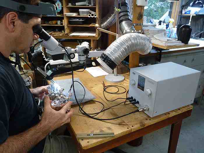Jeffrey Herman welding a split in a sterling coffeepot