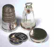 18c silver thimble with a clear glass perfume bottle and a separate compartment for four blue enamel game counters