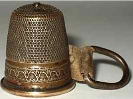 Early 20c brass thimbles containing tape measure