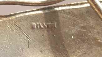 close-up of silver hallmarks on brooch backside
