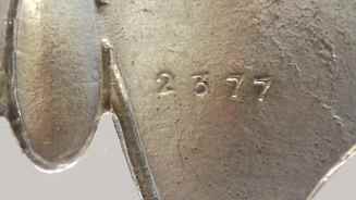 close up of silver hallmarks on brooch backside