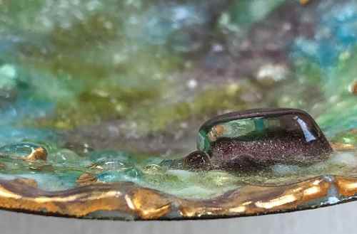 Close-up of enamel work: painted enamel on silver, incrusted with glass